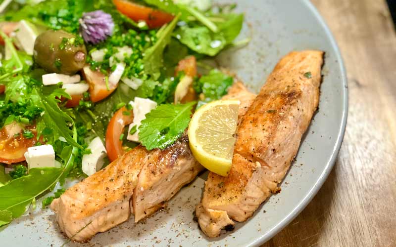 Limonen Lachs auf frischem Gartensalat - Nahaufnahme